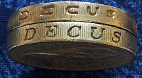 Fake pound coin on top, a genuine pound coin beneath for comparison